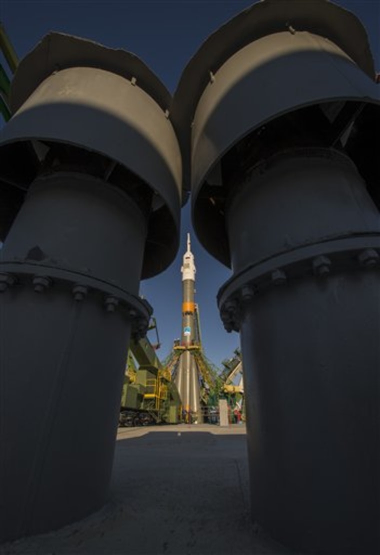 The Soyuz rocket is erected into position after being rolled out to the launch pad by train, on Sunday, Oct. 21, 2012, at the Baikonur Cosmodrome in Kazakhstan. 